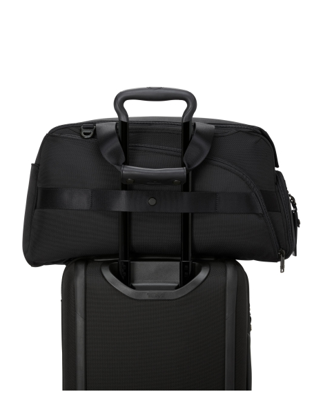 Sac de golf convertible TUMI Alpha Black, passant installé sur une poignée de valise