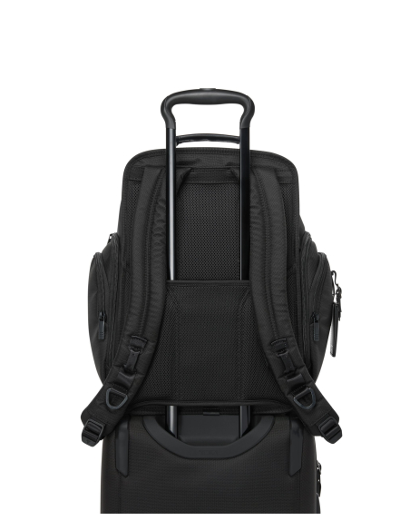 Sac à dos Brief Pack TUMI Alpha Black, passant installé sur une poignée de valise