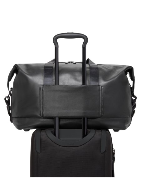 Sac de voyage à double extension 29 cm TUMI Alpha Black, passant installé sur une poignée de valise