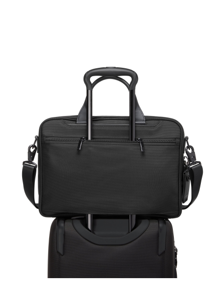 Porte-documents Medium TUMI Alpha Black, passant installé sur une poignée de valise