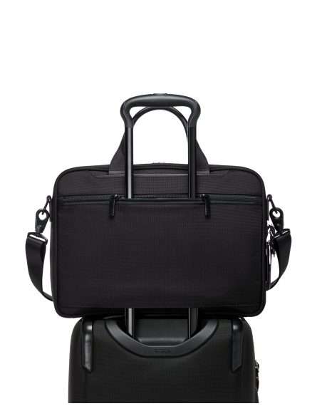 Porte-documents Medium TUMI Alpha Black, passant installé sur une poignée de valise