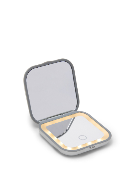 Miroir compact lumineux TUMI 19 Degree Aluminium Silver, vue de trois quarts avec éclairage chaud visible