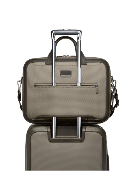 Porte-documents Slim Hannover TUMI Arrivé Taupe, dos installé sur une poignée de valise