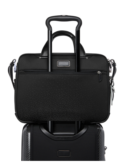 Porte-documents Slim Axle TUMI McLaren Night Galaxy, vue arrière sur la poignée d’une valise
