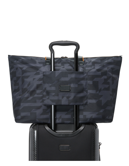 Sac cabas pliable Just In Case TUMI McLaren Black Camouflage, passant sur la poignée d’une valise