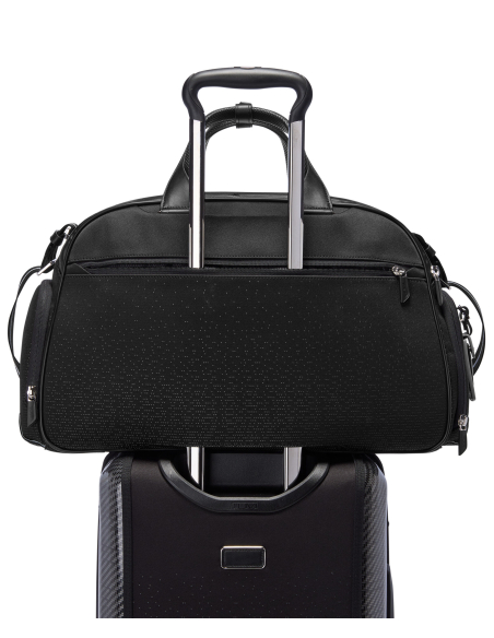 Sac de voyage Quantum TUMI McLaren Night Galaxy, passant sur la poignée d’une valise