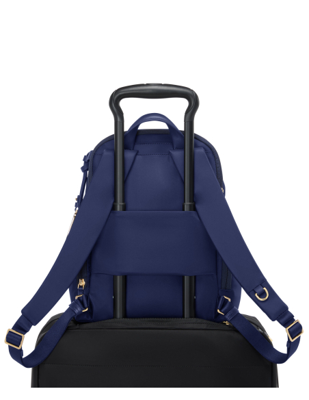 Sac à dos Medium Celina TUMI Indigo/Light Gold, fixé sur une valise