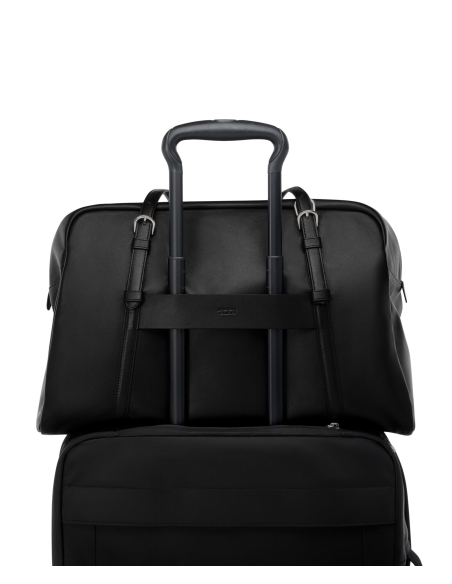 Sac cabas Oaklynn TUMI Black/Gunmetal, passant arrière sur une valise