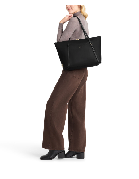 Sac cabas Q polyester TUMI noir porté à l’épaule, illustration du portage