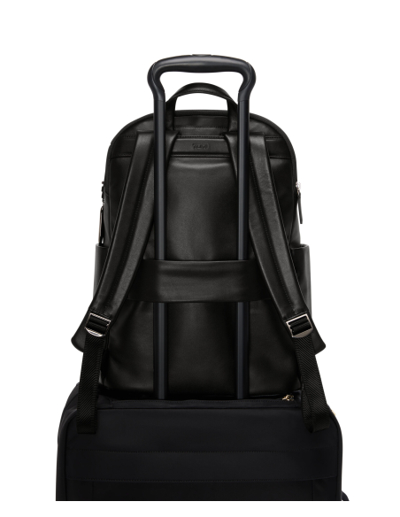 Sac à dos Raina cuir TUMI Black/Gunmetal, passant arrière sur une valise