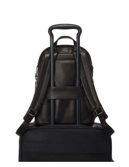Sac à dos Medium Raina cuir TUMI Black/Gunmetal, passant arrière sur une valise