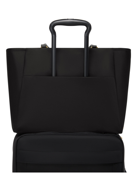 Grand sac cabas Valetta TUMI Black/Gold, passant arrière sur une valise
