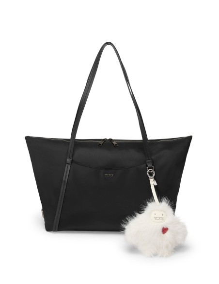 Bijou de sac TUMI Snow Monster Salt Faux Fur, bijou fixé à un cabas noir en situation