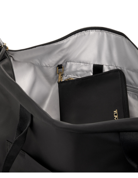 Pochette bijoux Vevay TUMI Voyageur Black/Gold, pochette placée dans un sac de voyage
