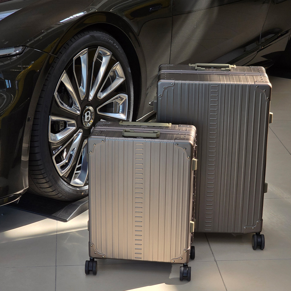 Deux valises ALEON en aluminium Bronze, une cabine et un grand format, &agrave; c&ocirc;t&eacute; d&rsquo;une voiture