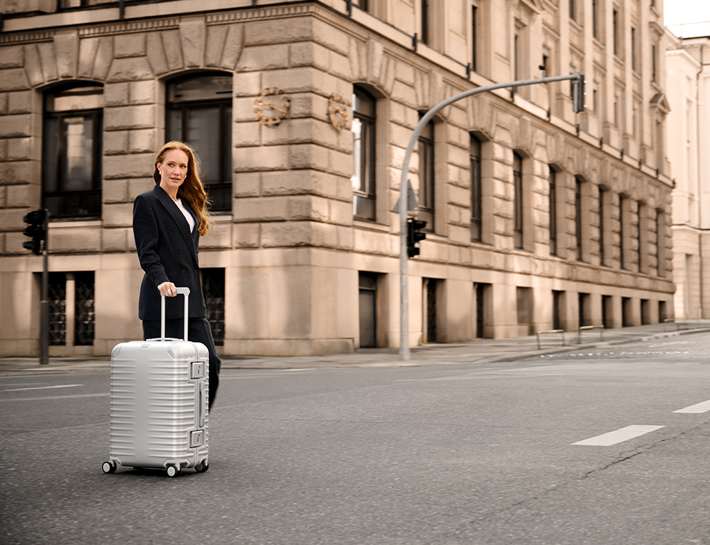 Voyageuse tirant une valise TITAN Eternity argentée dans une rue