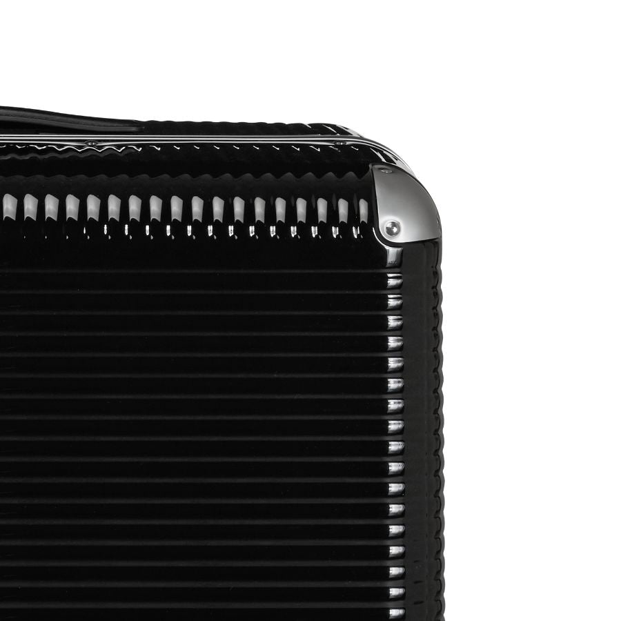 Détail de la coque nervurée en polycarbonate et du coin en aluminium d’une valise BANK LIGHT