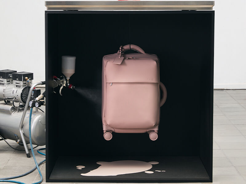 Valise rose Lipault dans une mise en scène de campagne autour de la couleur