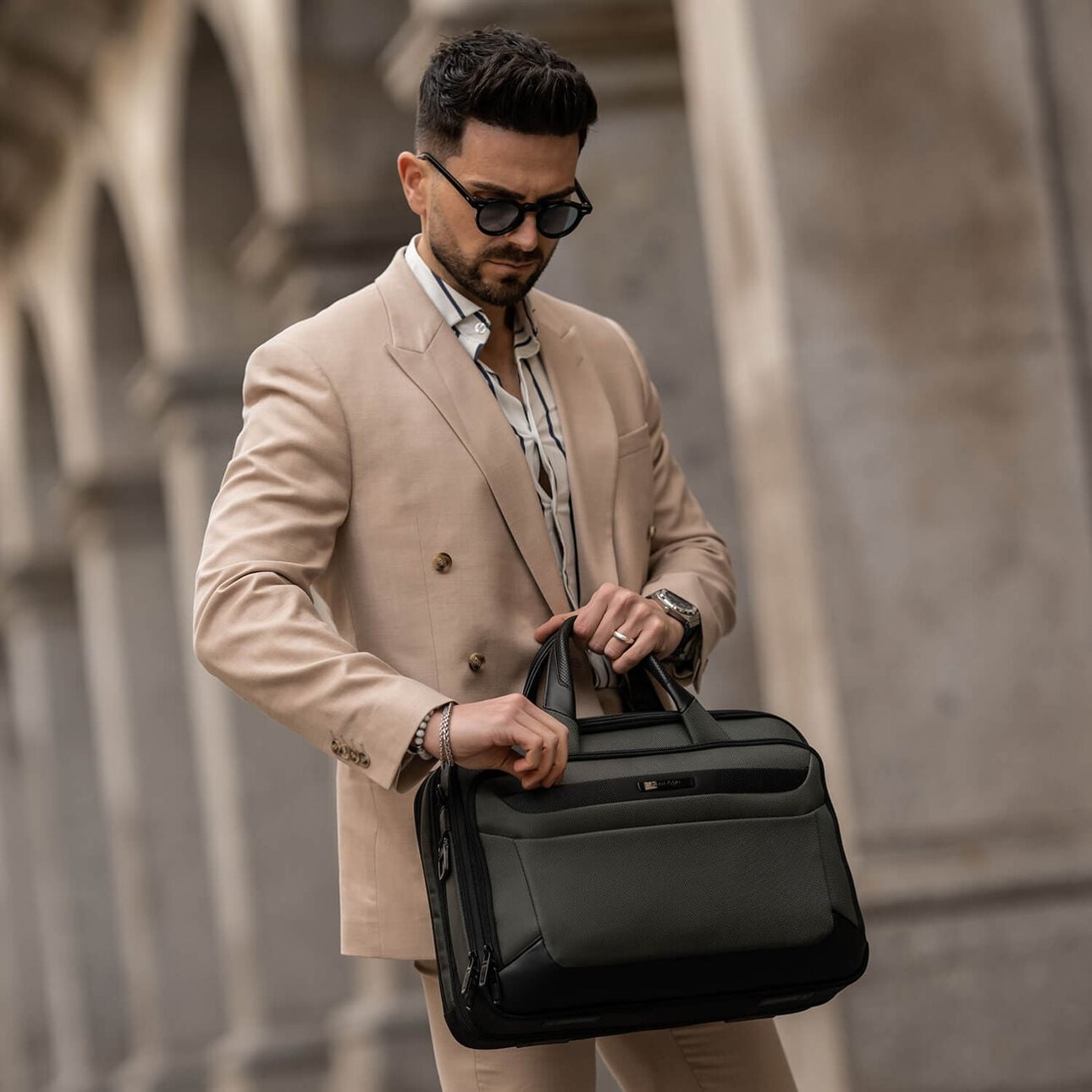 Voyageur portant une sacoche Samsonite Pro-DLX 6 noire &agrave; la main en ville