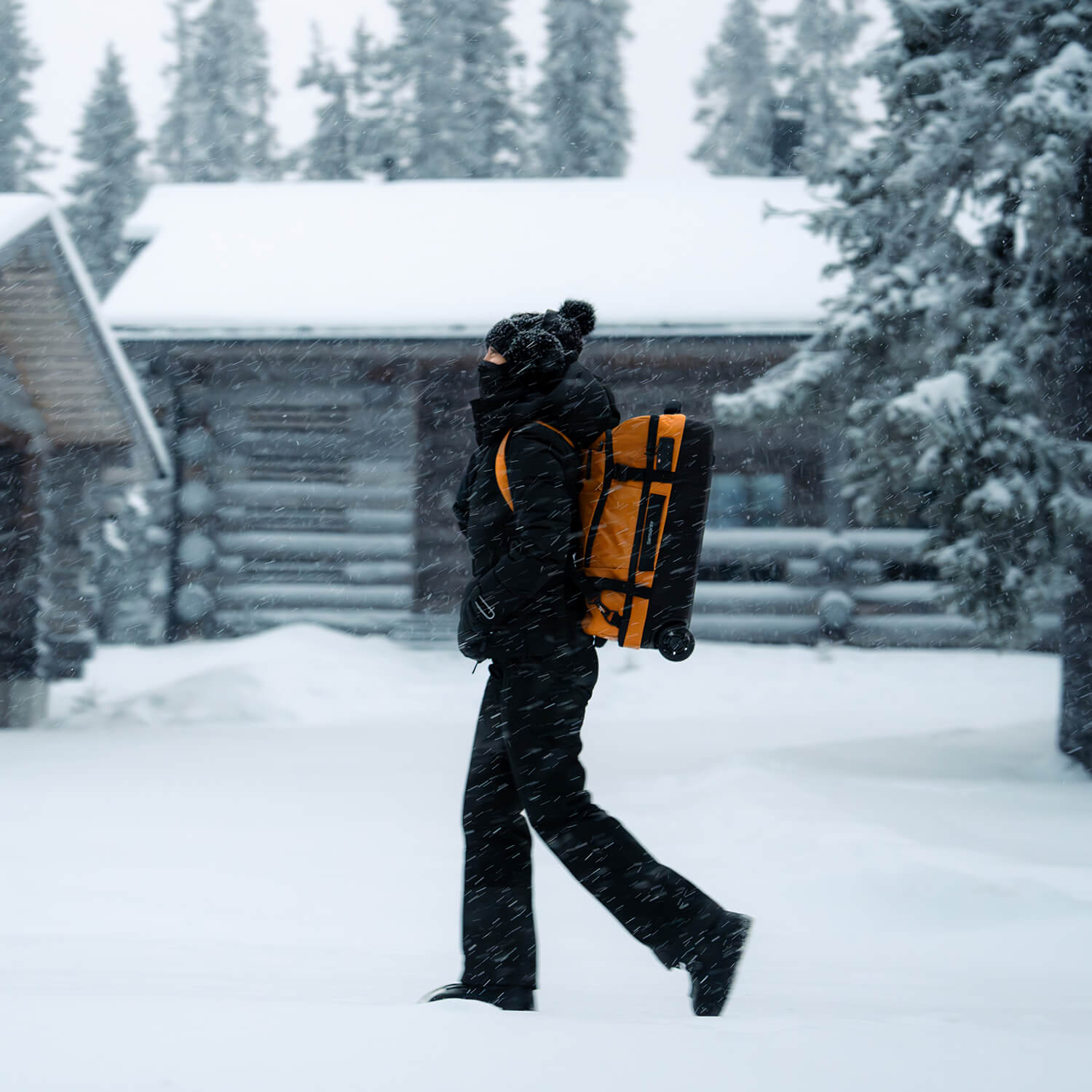 Voyageuse portant le sac cabine &agrave; roulettes Samsonite Armox Ocre sur le dos