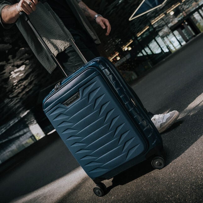 Voyageur avec une valise cabine Samsonite Proxis Easy Access bleue &agrave; poche frontale