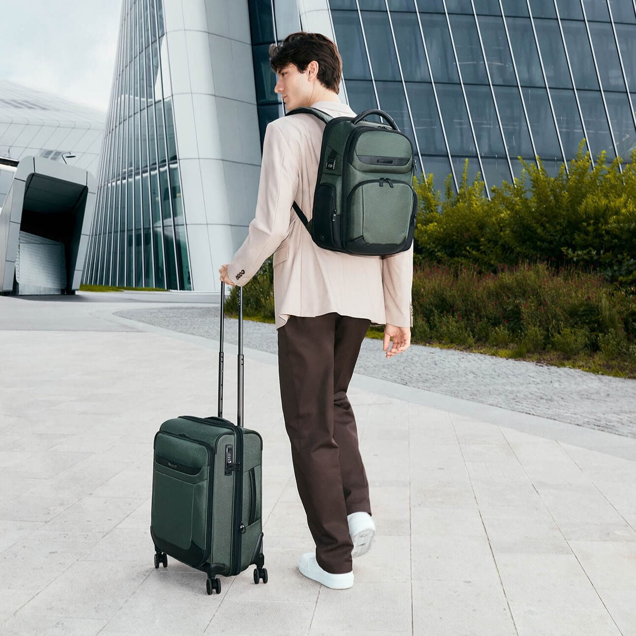 Voyageur avec un sac &agrave; dos et un bureau mobile Pro-DLX 6 &agrave; quatre roues