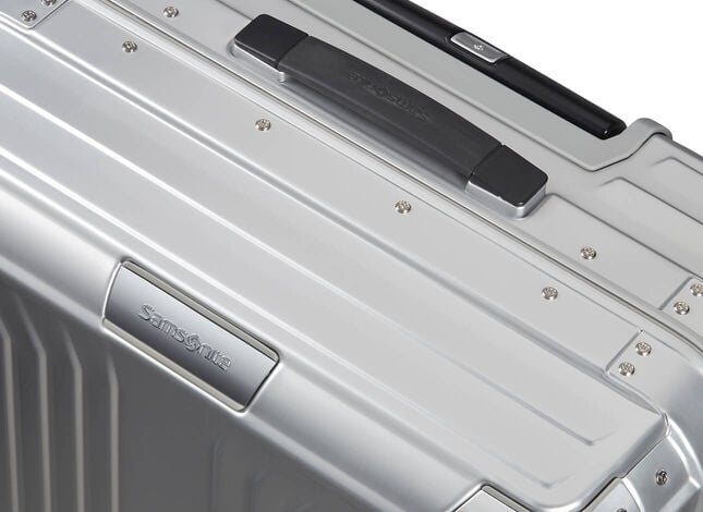 D&eacute;tail de la coque m&eacute;tallique et de la poign&eacute;e d&rsquo;une Samsonite Lite-Box Alu