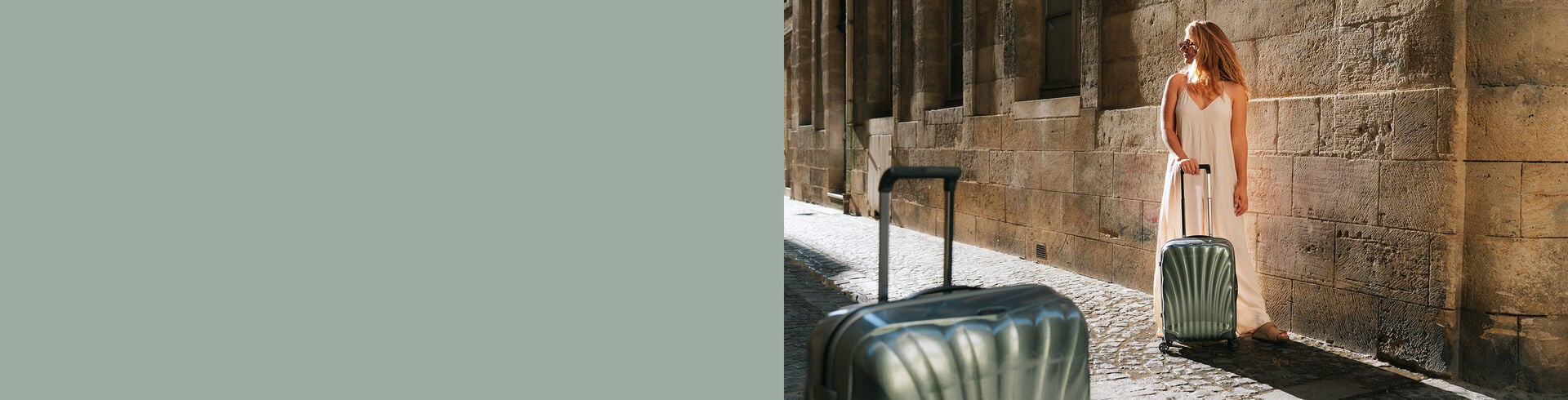 Voyageuse avec une valise Samsonite C-Lite dans une rue pavée