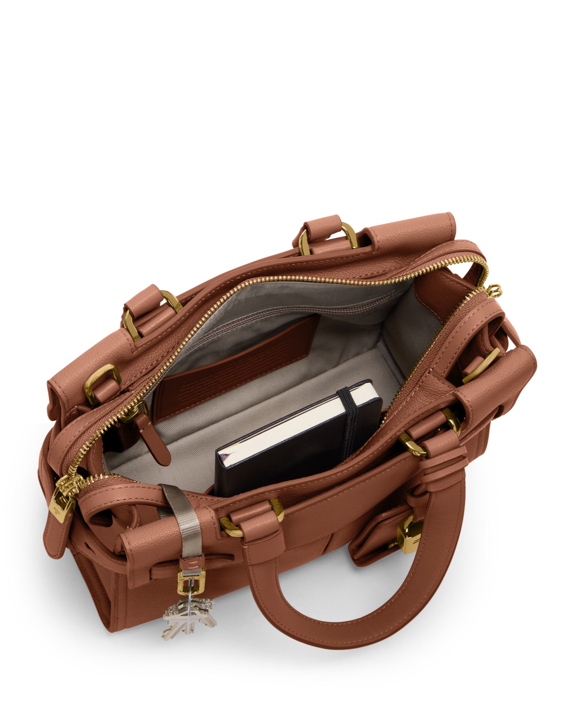 Petit cabas TUMI Agent ouvert avec des accessoires personnels en situation