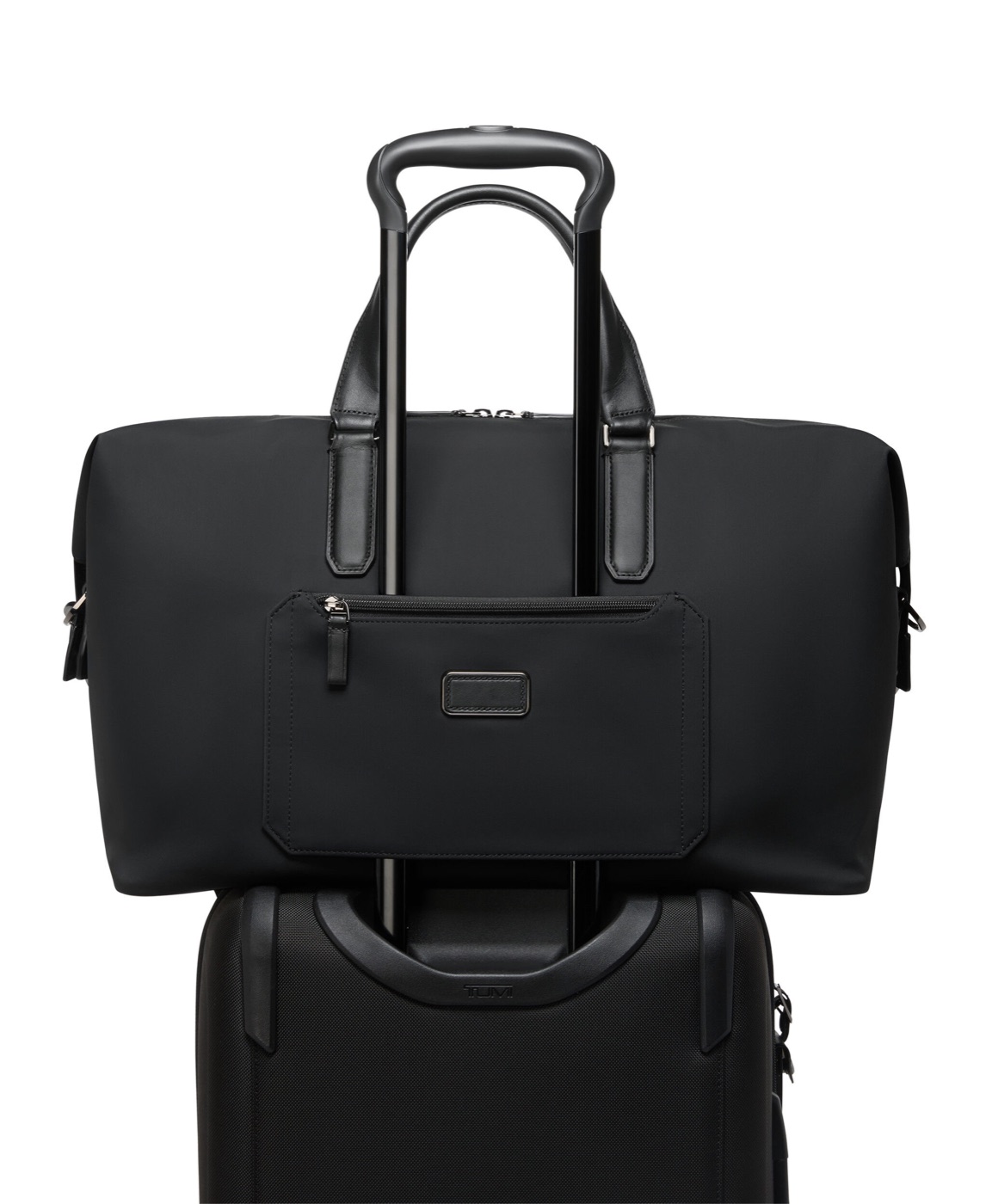 Sac de voyage Nelson Harrison en nylon fix&eacute; sur la poign&eacute;e d&rsquo;une valise par son passant Add-a-Bag