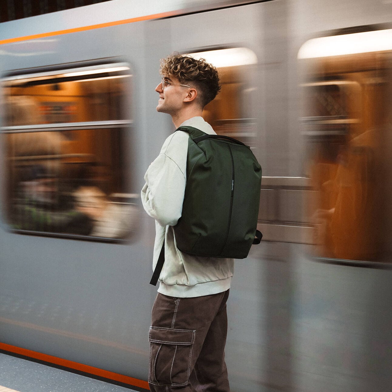 Voyageur portant un sac à dos Samsonite Securipak 2.0 vert dans une station de métro