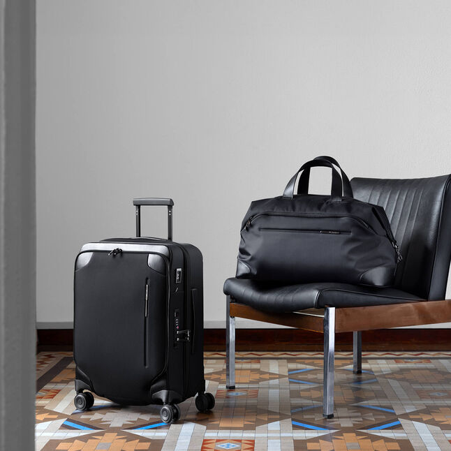 Une valise et un sac de voyage Samsonite Splendix noirs pr&eacute;sent&eacute;s dans un int&eacute;rieur.