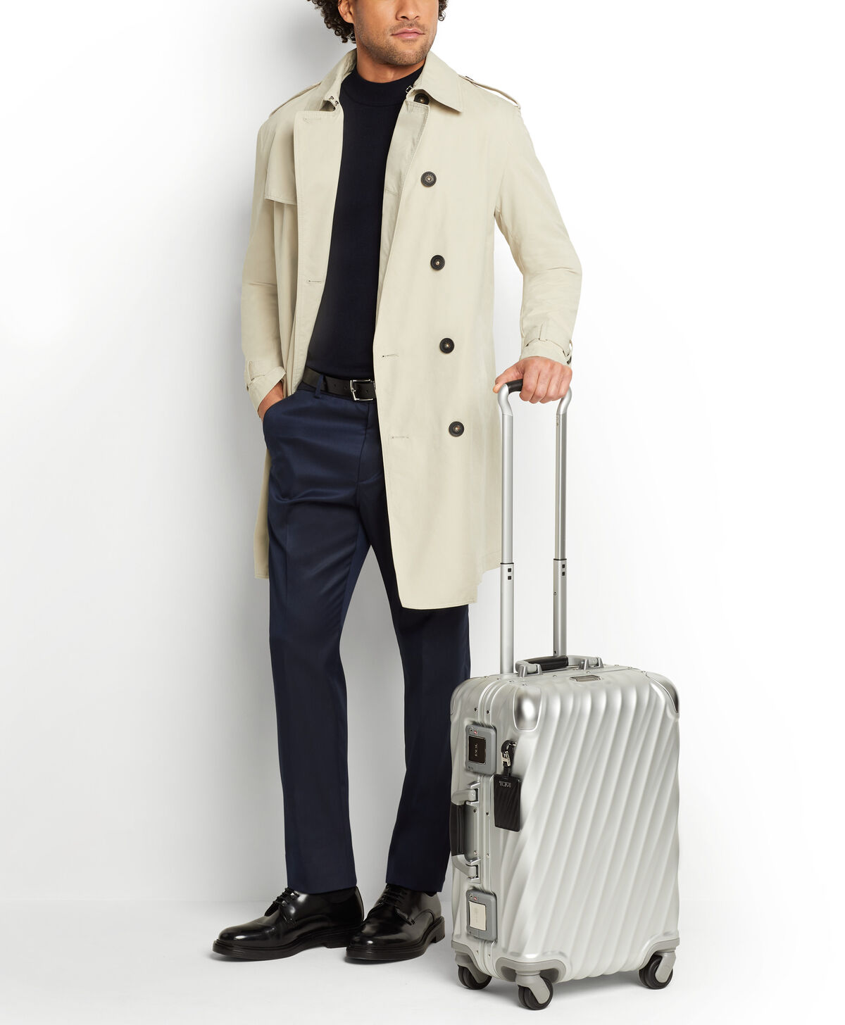 Valise cabine TUMI 19 Degree Aluminium Texture pr&eacute;sent&eacute;e &agrave; c&ocirc;t&eacute; d&rsquo;un voyageur