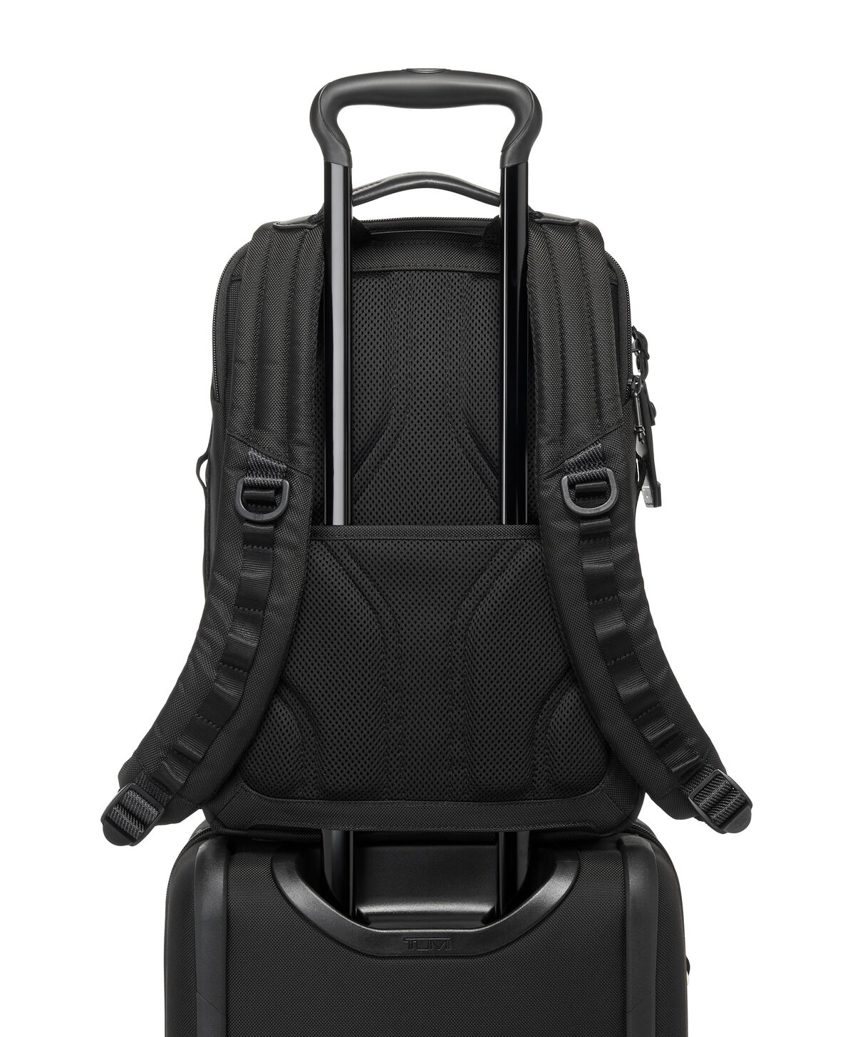 Sac TUMI Alpha Bravo Dynamic noir placé sur une valise avec son passant arrière